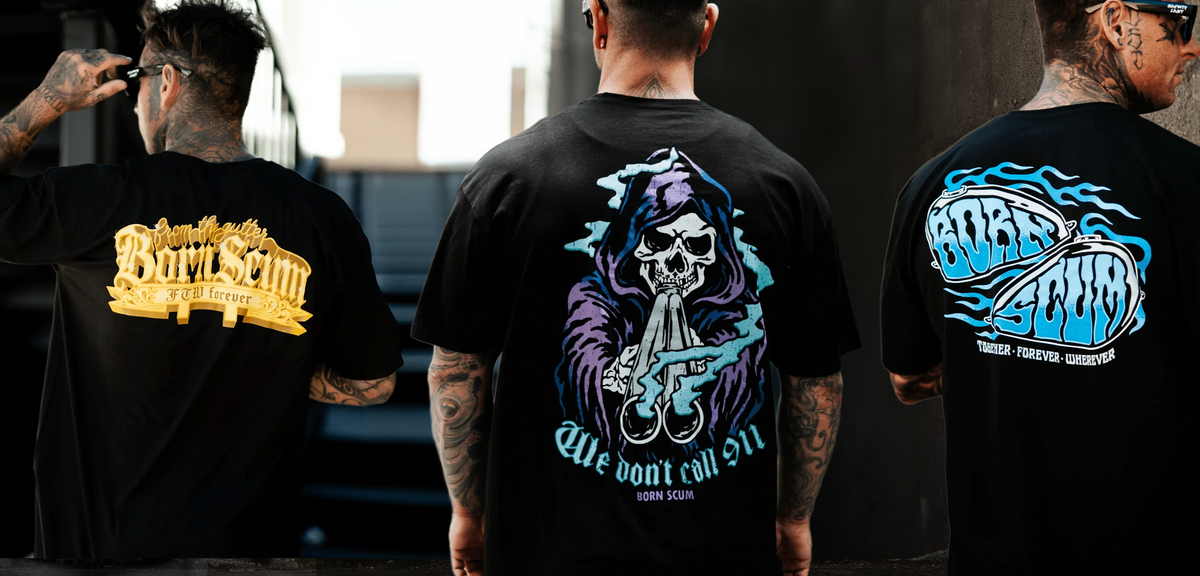 Three men shown from the back wearing black graphic t-shirts with large designs on the back. The center shirt features a purple and blue grim reaper graphic with a shotgun and the text 'We don't call 911'.